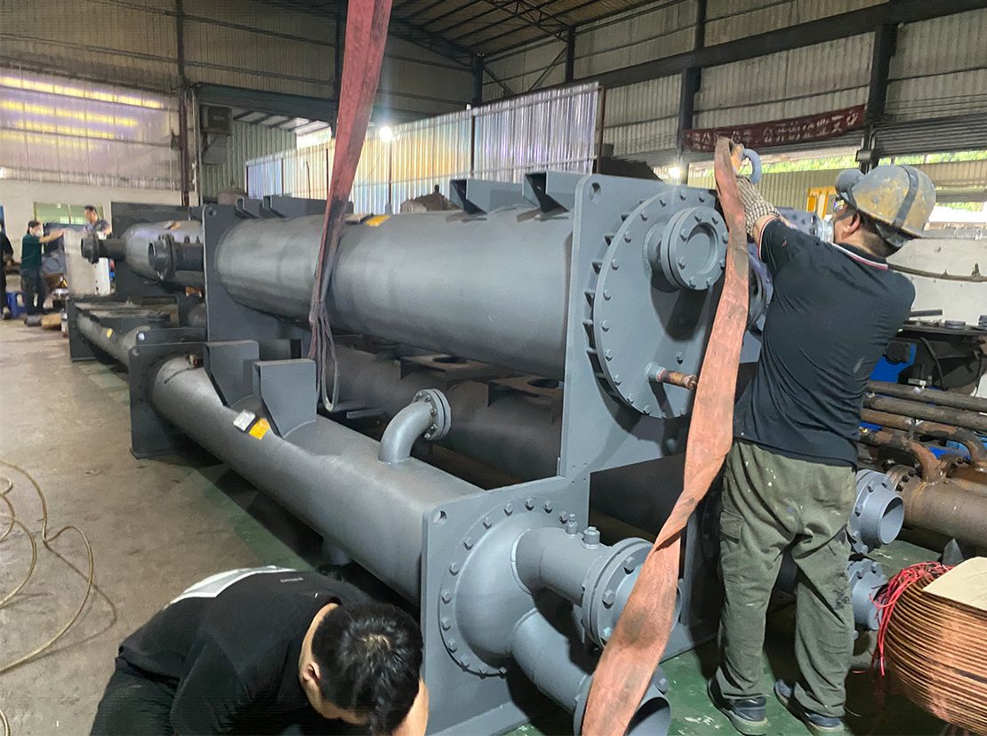 Two operators guiding a shell under the crane