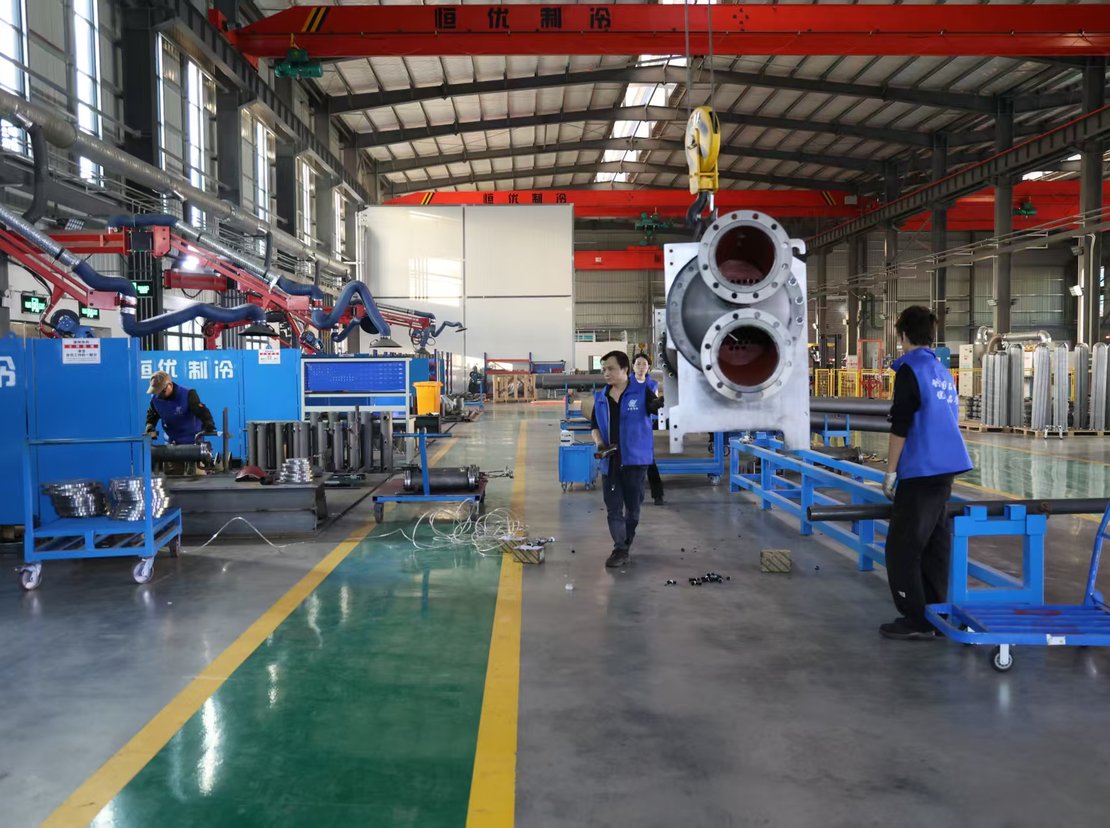 Overhead crane lifting a shell with two nozzle openings
